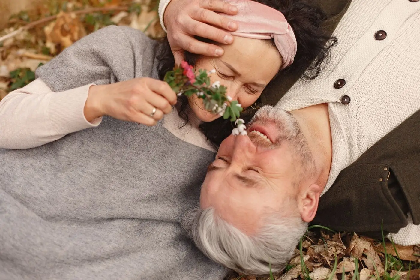 An older couple resting together outdoors, smiling